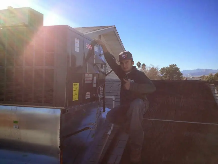 HVAC technician performing AC Tune-Up on a rooftop unit in Lantana
